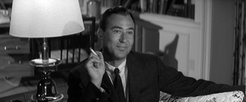 Movie still from “The Gazebo” (1959), directed by George Marshall – A black and white photo of a man in a suit and tie; Close Up shot, Over the shoulder angle