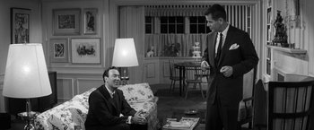 Movie still from “The Gazebo” (1959), directed by George Marshall – Two men in suits are sitting in a living room; Medium shot, Over the shoulder angle