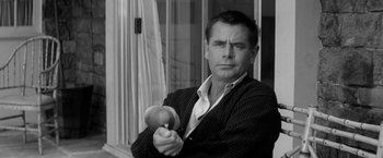 Movie still from “The Gazebo” (1959), directed by George Marshall – A black and white photo of a man holding a cricket bat; Close Up shot, Low angle