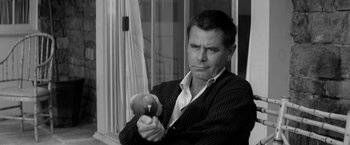 Movie still from “The Gazebo” (1959), directed by George Marshall – A black and white photo of a man holding an apple; Close Up shot, Over the shoulder angle