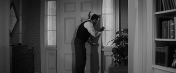 Movie still from “The Gazebo” (1959), directed by George Marshall – A black and white photo of a man opening a door; Medium shot, Low angle