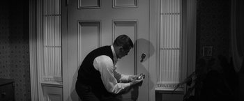 Movie still from “The Gazebo” (1959), directed by George Marshall – A black and white photo of a man playing a video game; Medium shot, High angle