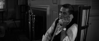 Movie still from “The Gazebo” (1959), directed by George Marshall – A black and white photo of a man talking on a phone; Close Up shot, High angle