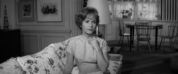 Movie still from “The Gazebo” (1959), directed by George Marshall – An older woman sitting on top of a floral couch; Medium shot, Low angle