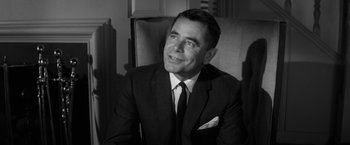 Movie still from “The Gazebo” (1959), directed by George Marshall – Black and white photograph of a man wearing a suit; Close Up shot, Over the shoulder angle