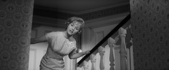 Movie still from “The Gazebo” (1959), directed by George Marshall – A black and white photo of a woman holding a baseball bat; Medium shot, Low angle