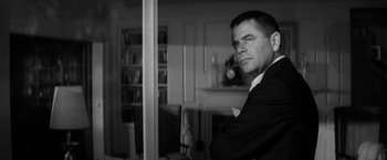 Movie still from “The Gazebo” (1959), directed by George Marshall – Black and white photograph of a man standing in a living room; Close Up shot, Low angle