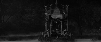 Movie still from “The Gazebo” (1959), directed by George Marshall – An ornate gazebo is surrounded by flowers and birds; Wide shot, High angle