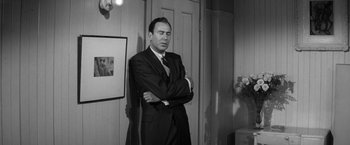 Movie still from “The Gazebo” (1959), directed by George Marshall – Black and white photograph of a man in a suit; Medium shot, Over the shoulder angle