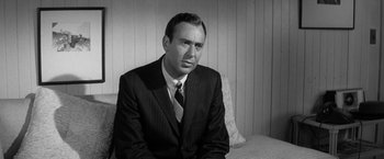 Movie still from “The Gazebo” (1959), directed by George Marshall – Black and white photograph of a man wearing a suit and tie; Close Up shot, Low angle