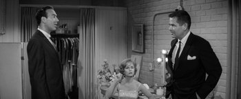 Movie still from “The Gazebo” (1959), directed by George Marshall – A black - and - white photo of a woman in front of a mirror; Medium shot, Over the shoulder angle