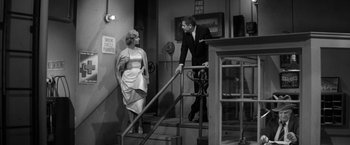 Movie still from “The Gazebo” (1959), directed by George Marshall – A man and a woman standing at the top of a stair railing; Wide shot, Low angle