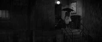 Movie still from “The Gazebo” (1959), directed by George Marshall – A person holding an umbrella in the rain; Wide shot, High angle