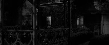 Movie still from “The Gazebo” (1959), directed by George Marshall – A black - and - white photo of a building with a window; Wide shot, Low angle