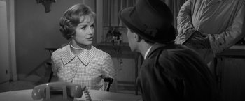 Movie still from “The Gazebo” (1959), directed by George Marshall – A woman and a man sitting at a dining table; Medium shot, Over the shoulder angle