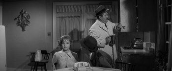 Movie still from “The Gazebo” (1959), directed by George Marshall – An old photo of a man and a woman at a dinner table; Medium shot, Over the shoulder angle