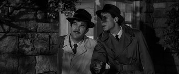 Movie still from “The Gazebo” (1959), directed by George Marshall – A couple of men wearing hats and jackets; Close Up shot, Low angle