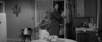 Movie still from “The Gazebo” (1959), directed by George Marshall – A man in a trench coat is standing in front of a woman; Medium shot, Over the shoulder angle