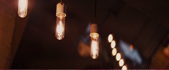 Movie still from “The Girlfriend Experience” (2009), directed by Steven Soderbergh – Two light bulbs hanging from a ceiling in a dark room; Extreme Close Up shot, Low angle