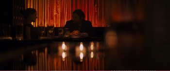Movie still from “The Girlfriend Experience” (2009), directed by Steven Soderbergh – A man sitting at a table in front of candles; Medium shot, Over the shoulder angle