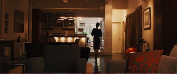 Movie still from “The Girlfriend Experience” (2009), directed by Steven Soderbergh – A person walking in a living room with lights on; Wide shot, Low angle