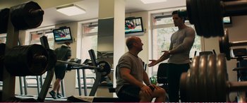 Movie still from “The Girlfriend Experience” (2009), directed by Steven Soderbergh – Two men are talking in a gym together; Wide shot, Over the shoulder angle