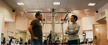 Movie still from “The Girlfriend Experience” (2009), directed by Steven Soderbergh – Two men standing in a gym talking to each other; Medium shot, Over the shoulder angle