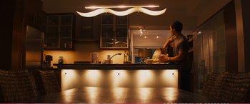 Movie still from “The Girlfriend Experience” (2009), directed by Steven Soderbergh – A woman standing at a counter in a kitchen; Wide shot, Low angle