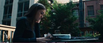 Movie still from “The Girlfriend Experience” (2009), directed by Steven Soderbergh – A woman sitting at an outdoor table looking at her cell phone; Medium shot, High angle