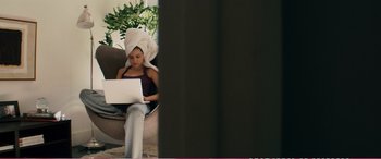 Movie still from “The Girlfriend Experience” (2009), directed by Steven Soderbergh – A woman sitting on a chair using a computer; Medium shot, Over the shoulder angle