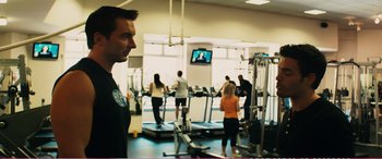 Movie still from “The Girlfriend Experience” (2009), directed by Steven Soderbergh – A group of people in a gym watching a television; Medium shot, Over the shoulder angle