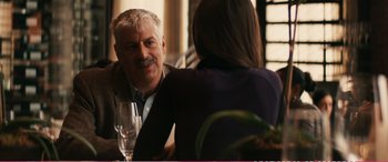 Movie still from “The Girlfriend Experience” (2009), directed by Steven Soderbergh – An older man sitting at a table with a glass of white wine; Medium shot, Over the shoulder angle