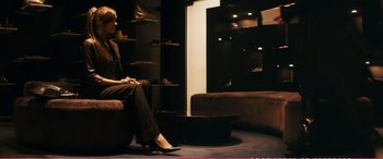 Movie still from “The Girlfriend Experience” (2009), directed by Steven Soderbergh – A woman sitting on top of a couch in a room; Wide shot, Over the shoulder angle