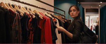 Movie still from “The Girlfriend Experience” (2009), directed by Steven Soderbergh – A woman is looking at clothes hanging on a rack; Medium shot, Over the shoulder angle