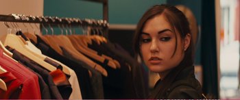 Movie still from “The Girlfriend Experience” (2009), directed by Steven Soderbergh – A woman standing in front of a rack of clothes; Close Up shot, Over the shoulder angle