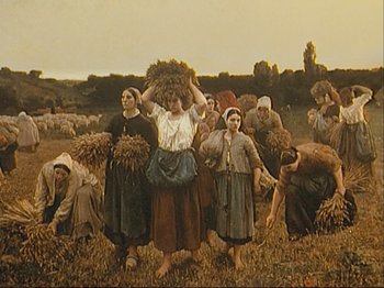 Movie still from “The Gleaners & I” (2000), directed by Agnès Varda – A group of people in a field with a bunch of hay on their heads; Wide shot, Low angle