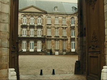 Movie still from “The Gleaners & I” (2000), directed by Agnès Varda – An image of an old building in the middle of the day; Extreme Wide shot, High angle