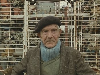 Movie still from “The Gleaners & I” (2000), directed by Agnès Varda – An older man wearing a hat and a scarf; Close Up shot, Low angle