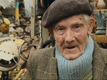 Movie still from “The Gleaners & I” (2000), directed by Agnès Varda – An old man wearing a hat and a scarf; Close Up shot, Low angle