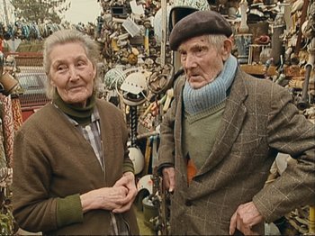 Movie still from “The Gleaners & I” (2000), directed by Agnès Varda – An older man and woman standing next to each other; Medium shot, High angle