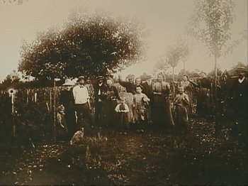 Movie still from “The Gleaners & I” (2000), directed by Agnès Varda – A group of men standing next to each other in a field; Wide shot, Low angle