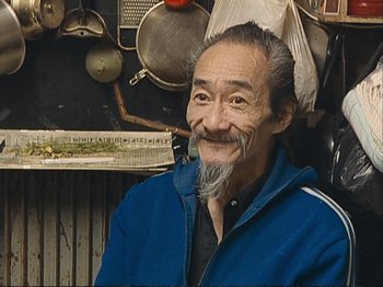 Movie still from “The Gleaners & I” (2000), directed by Agnès Varda – An older man with a beard and a hat on; Close Up shot, High angle