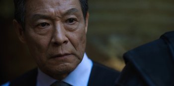 Movie still from “Altered Carbon” (2018), created by Laeta Kalogridis – An older asian man in a suit and tie; Close Up shot, Over the shoulder angle