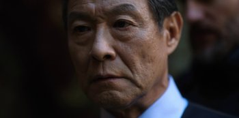 Movie still from “Altered Carbon” (2018), created by Laeta Kalogridis – An older asian man in a white shirt and blue tie; Close Up shot, Low angle