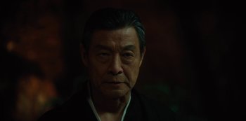 Movie still from “Altered Carbon” (2018), created by Laeta Kalogridis – An older man wearing a black shirt and a black robe; Close Up shot, Low angle