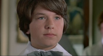 Movie still from “The Go-Between” (1971), directed by Joseph Losey – A young man wearing a white shirt and a bow tie; Close Up shot, Low angle