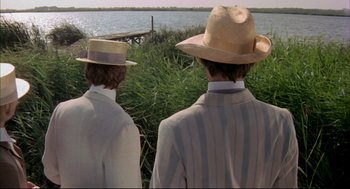 Movie still from “The Go-Between” (1971), directed by Joseph Losey – Two men in suits and straw hats looking out at the water; Medium shot, Over the shoulder angle