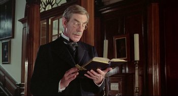 Movie still from “The Go-Between” (1971), directed by Joseph Losey – An older man in a suit and tie holding an open book; Close Up shot, Low angle