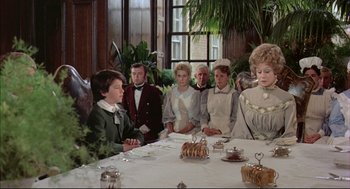 Movie still from “The Go-Between” (1971), directed by Joseph Losey – A group of people sitting around a table; Medium shot, Over the shoulder angle