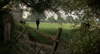 Movie still from “The Go-Between” (1971), directed by Joseph Losey – A person standing in a field near a fence; Extreme Wide shot, High angle